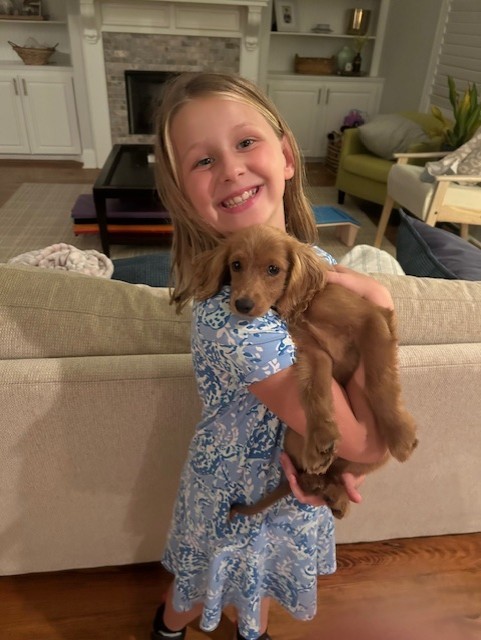 Dr. Filingim's daughter poses with her cockapoo puppy, Marshall. 